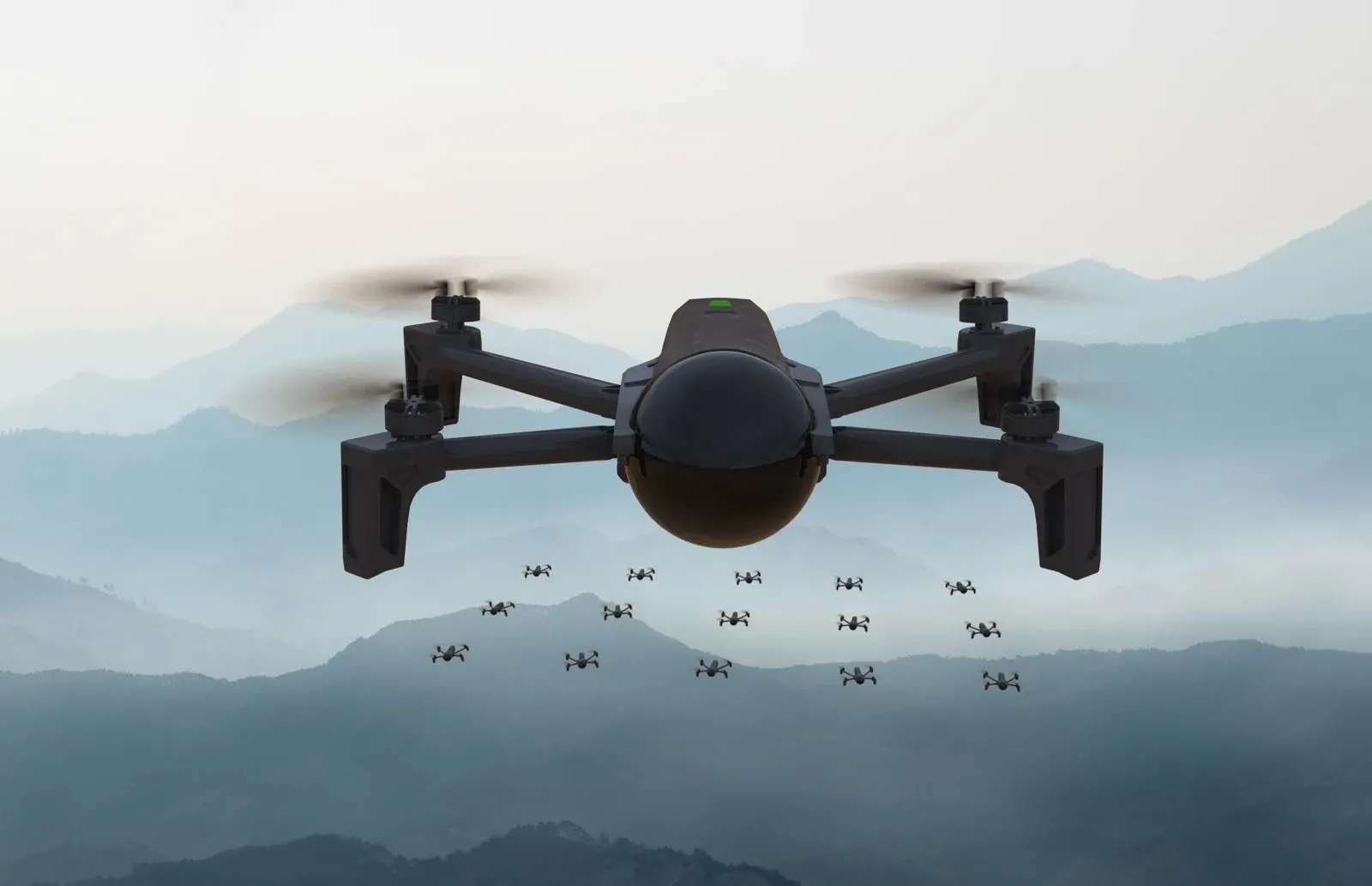 Un drone quadrirotor en vol, vu de face, au premier plan. Derrière lui, une quinzaine d'autres drones tiennent une formation régulière au-dessus d'un paysage de montagnes brumeuses.